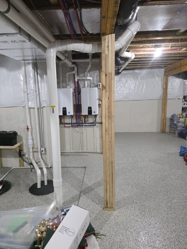 Unfinished basement with radon mitigation pipes, exposed ductwork, wiring, and a central wooden support post.